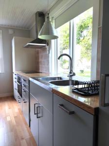 una cocina con fregadero y ventana en Small Cottage, en Jönköping