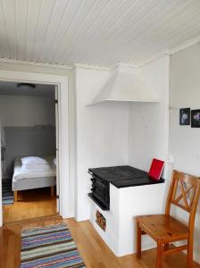 Una habitación con una mesa y una computadora portátil roja sobre una estufa. en Small Cottage, en Jönköping