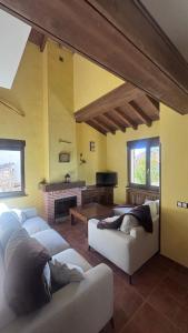 a living room with couches and a fireplace at Casa la Cabañuela in Navarredonda de Gredos