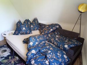 een bed met blauwe dekens en kussens erop bij Ferienwohnung Nr 2 am Hambach in Falkenbach