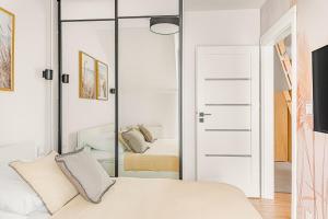 a bedroom with a mirror and a bed at Cortaderia Haven - SPA - Basen, Jacuzzi, Sauna & Parking in Ustronie Morskie