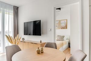 a living room with a table and a bed at Cortaderia Haven - SPA - Basen, Jacuzzi, Sauna & Parking in Ustronie Morskie