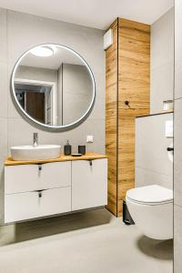 a bathroom with a white sink and a mirror at Cortaderia Haven - SPA - Basen, Jacuzzi, Sauna & Parking in Ustronie Morskie
