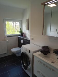 een badkamer met wasmachine en toilet bij Ferienwohnung Nr 2 am Hambach in Falkenbach