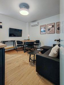 Una sala de estar con un sofá y una mesa con sillas. en Black Lion, en Villena