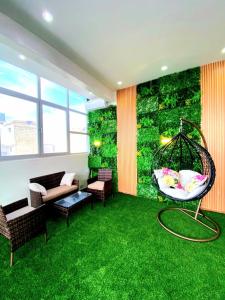 a room with a green wall with a swing at Eden- Jacuzzi Privé et Terasse à 5mn de la plage in Dakar