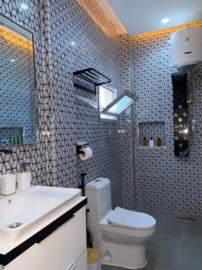a bathroom with a toilet and a sink and a mirror at Eden- Jacuzzi Privé et Terasse à 5mn de la plage in Dakar +14 photos