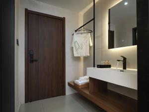 un baño con lavabo y espejo en Zhangjiajie JoyMaple Hotel, en Zhangjiajie 38 fotos más