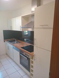 eine Küche mit weißen Schränken und einem Herd mit Backofen in der Unterkunft Wohnung im Herzen der Altstadt in Bonn