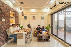 EKOSTAY - Kara Villa في كارجات: مجموعة من الناس يجلسون على طاولة في غرفة