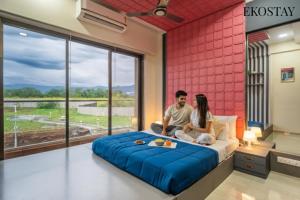 EKOSTAY - Kara Villa في كارجات: رجل وامرأة يجلسان على سرير في غرفة النوم