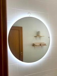 a round mirror on a wall with a door at Miguel Surf House in Costa da Caparica +17 photos