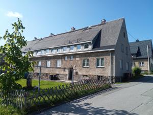 een oud bakstenen gebouw met een grijs dak bij Ferienwohnung Nr 2 am Hambach in Falkenbach