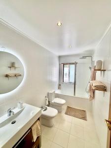a bathroom with a toilet and a tub and a sink at Miguel Surf House in Costa da Caparica