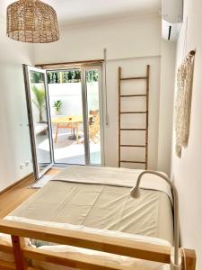 a bed in a room with a view of a patio at Miguel Surf House in Costa da Caparica