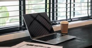 坎古Kiara Ocean Place的坐在窗边的桌子上的笔记本电脑