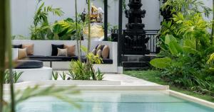 坎古Kiara Ocean Place的花园里的游泳池，配有家具和植物。 更多47张照片