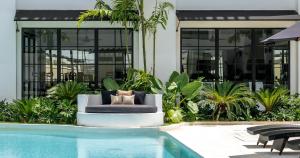 a couch sitting next to a swimming pool at Kiara Ocean Place in Canggu