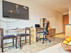 Zimmer mit einem Schreibtisch und Stühlen sowie einem TV an der Wand in der Unterkunft Studio Domaine des Reines by Interhome in Nendaz