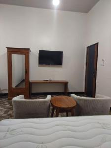 a bedroom with a bed and a table and chairs at See Sea Hostel & Resto in Jepara