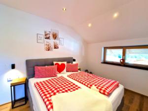 a bedroom with a large bed with red and white blankets at Apartment Wildschütz by Interhome in Weerberg