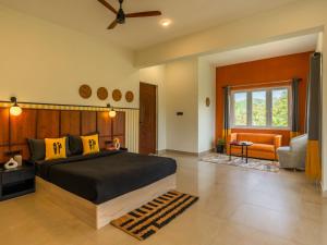a bedroom with a large bed and a living room at The Hosteller Bam Coorg in Madikeri