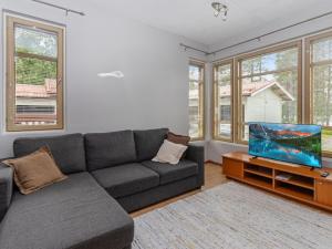 a living room with a couch and a flat screen tv at Holiday Home Rantala 2 by Interhome in Ranua