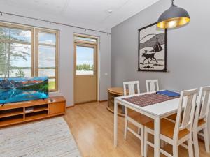 a dining room with a table and a tv at Holiday Home Rantala 2 by Interhome in Ranua