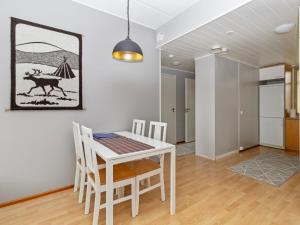 a dining room with a white table and chairs at Holiday Home Rantala 2 by Interhome in Ranua +8 photos