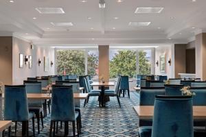 a dining room with tables and chairs and windows at Thon Hotel Saga in Haugesund
