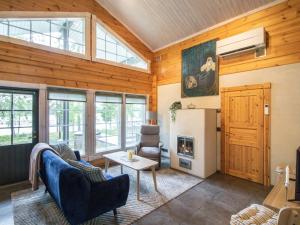 a living room with wood paneled walls and a fireplace at Holiday Home Villa white water by Interhome in Kainuu