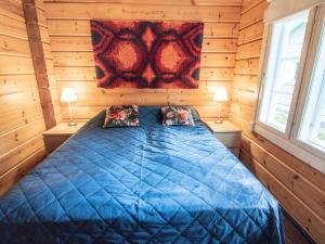 a bedroom with a blue bed in a wooden cabin at Holiday Home Villa white water by Interhome in Kainuu +22 photos