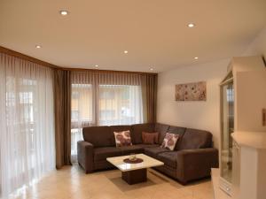 a living room with a brown couch and a table at Apartment Dominic B2 by Interhome in Saas-Fee +14 photos