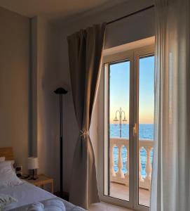 a bedroom with a window with a view of the ocean at Aquamaris in Giovinazzo