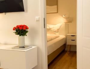 een kamer met een bed en een vaas met bloemen op een tafel bij Neu! Hirschgrund 10 OG Panorama, Sauna, Pool in Braunlage +28 foto's