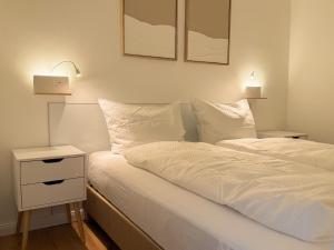 een slaapkamer met een bed en een nachtkastje met 2 lampen bij Neu! Hirschgrund 10 OG Panorama, Sauna, Pool in Braunlage