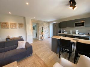 a kitchen and living room with a couch and a table at Mas de Veyras - Gîtes 5 étoiles en Ardèche in Lachapelle Sous Aubenas