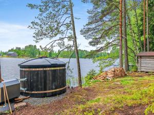 a large black object sitting next to a body of water at Holiday Home Louhikko by Interhome in Houhajärvi