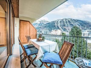 Un balcón con mesa y sillas y montañas. en Apartment Chesa Promulins by Interhome, en Samedan