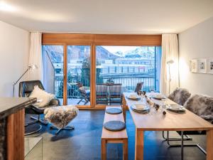 Una sala de estar con una mesa y una gran ventana. en Apartment Chesa Promulins by Interhome, en Samedan 12 fotos más