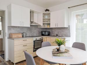 Holiday Home Lakeside Village 39 by Interhome في Lojzova Paseka: مطبخ مع دواليب بيضاء وطاولة مع كراسي