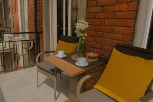a table with two chairs and a vase of flowers at Your Home Inn at Jikia's Green House-Central Tbilisi in Tbilisi City +10 photos