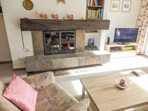 a living room with a fireplace and a tv at Apartment Curnera 9-4 by Interhome in Laax-Murschetg
