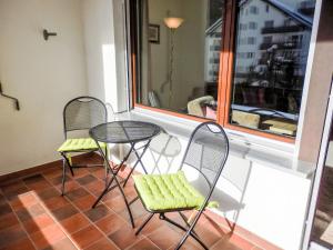 two chairs and a table in front of a window at Apartment Curnera 9-4 by Interhome in Laax-Murschetg +16 photos