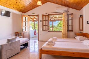 a bedroom with two beds and a window at Amalia Studios Skiathos in Skiathos Town