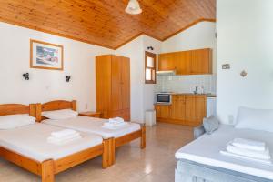 two beds in a room with a kitchen at Amalia Studios Skiathos in Skiathos Town