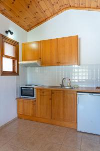 a kitchen with wooden cabinets and a white refrigerator at Amalia Studios Skiathos in Skiathos Town +22 photos