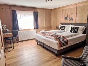 a bedroom with a bed and a table and a desk at Apartment Edelweiss-Stube by Interhome in Klosters Serneus