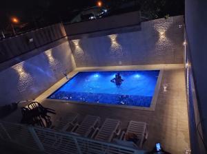 an overhead view of a swimming pool with chairs and lights at Apartamento completo com wi-fi e piscina in Ubatuba