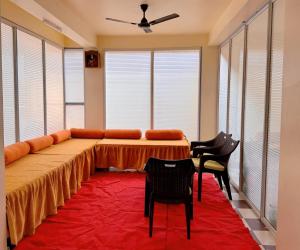 Zimmer mit einem Tisch und Stühlen auf einem roten Teppich in der Unterkunft Studio 402 Continental stay in Deoghar